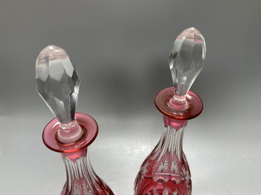 A pair of flash cut cranberry glass decanters and stoppers, height 39.5cm